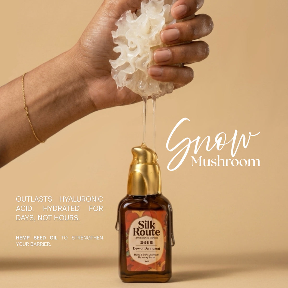 A hand holding a frilled white Snow Mushroom above the Dew of Dunhuang bottle